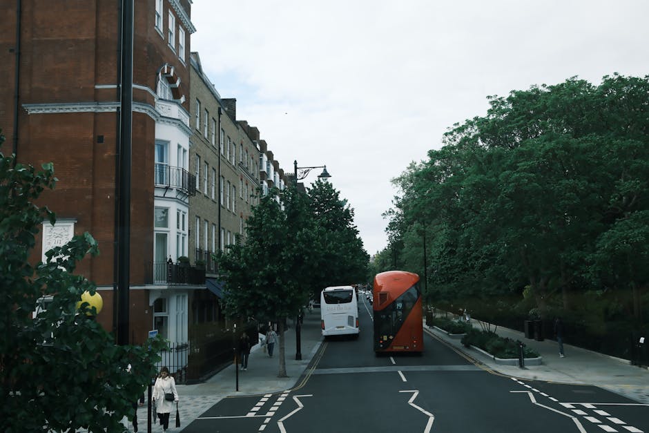 A rectangular white street sign mounted on a black metal pole pointing straight ahead with an upward arrow, indicating the direction to Arsenal Station. The sign features the London Underground rounde